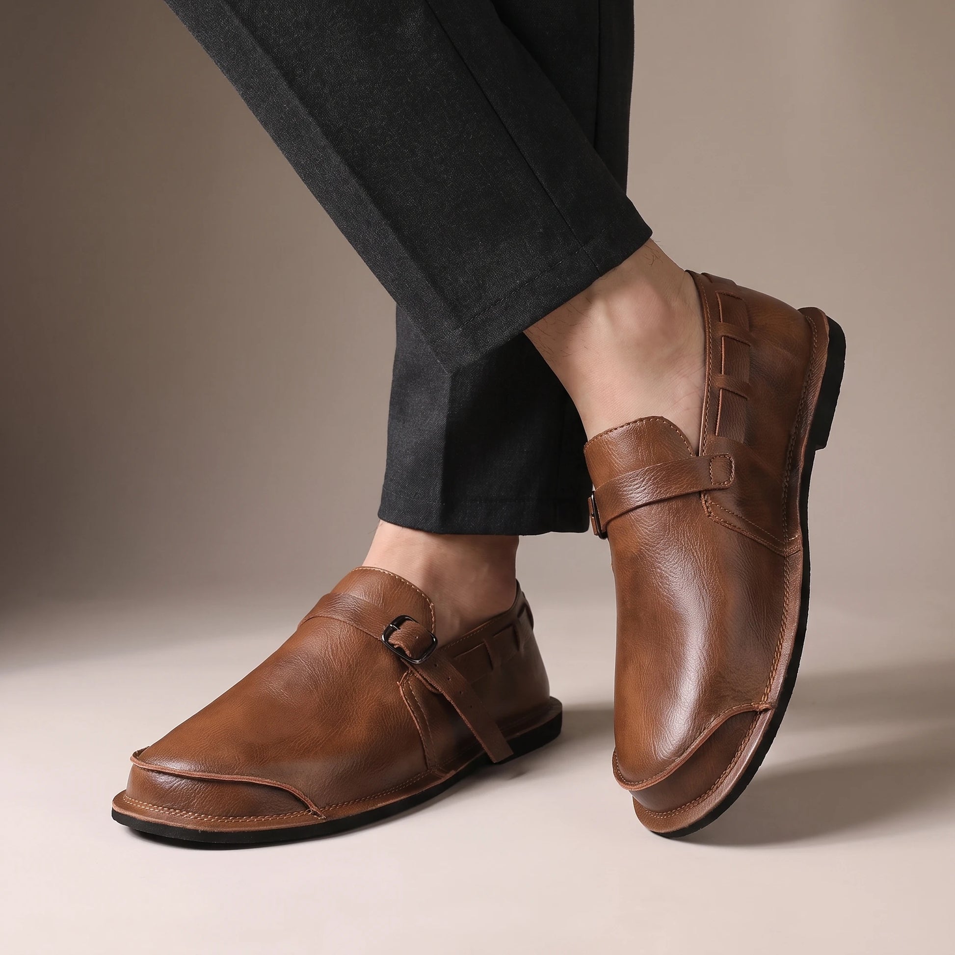 CLASSIC SLIP-ON LOAFERS worn by a man in dark trousers, crossed-ankles view