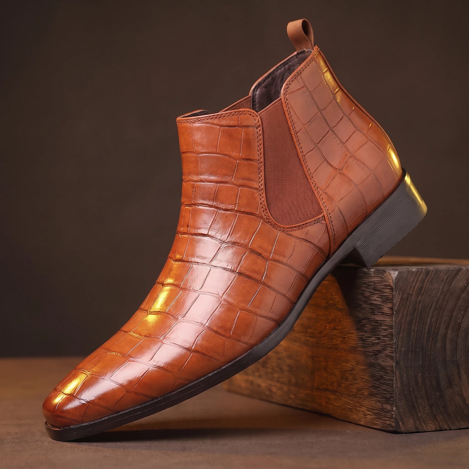 CROC GRAIN BOOTS rust light-brown croc-texture platform Chelsea boot on a smoked-oak block, moody amber light