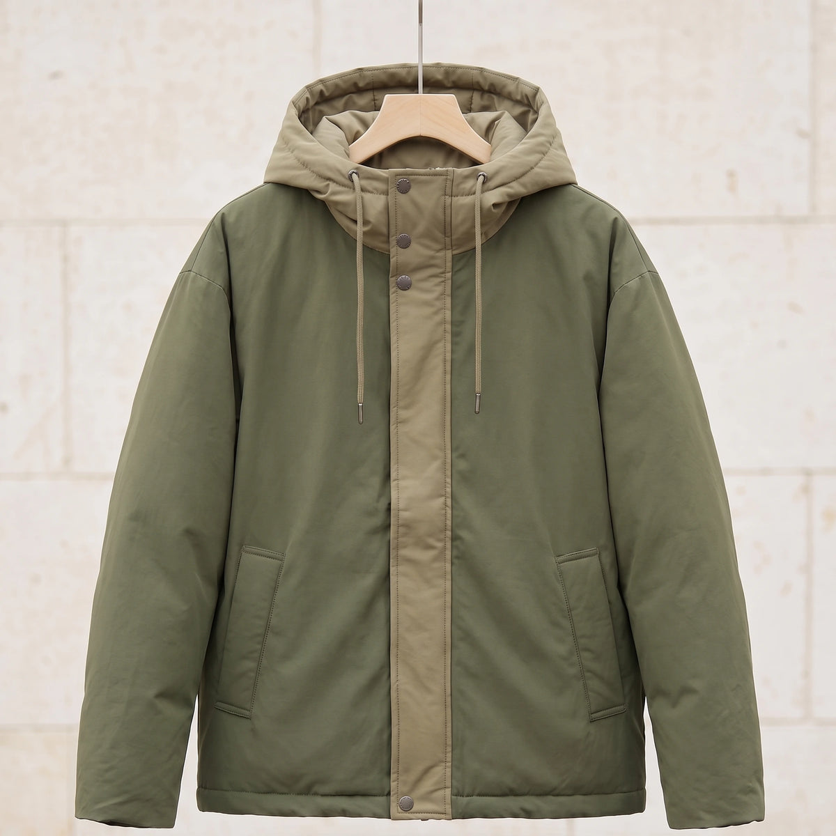Green padded hooded parka with khaki hood and front panel on a wooden hanger, front view