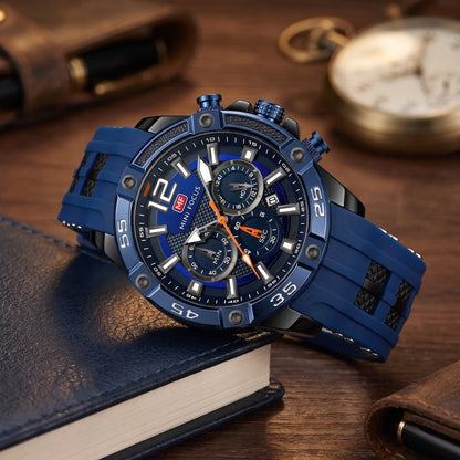 Men's blue sport chronograph watch with screw-set bezel and blue silicone strap, resting on leather-bound books