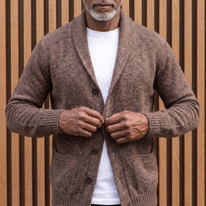 Man fastening the buttons on the brown shawl collar cardigan