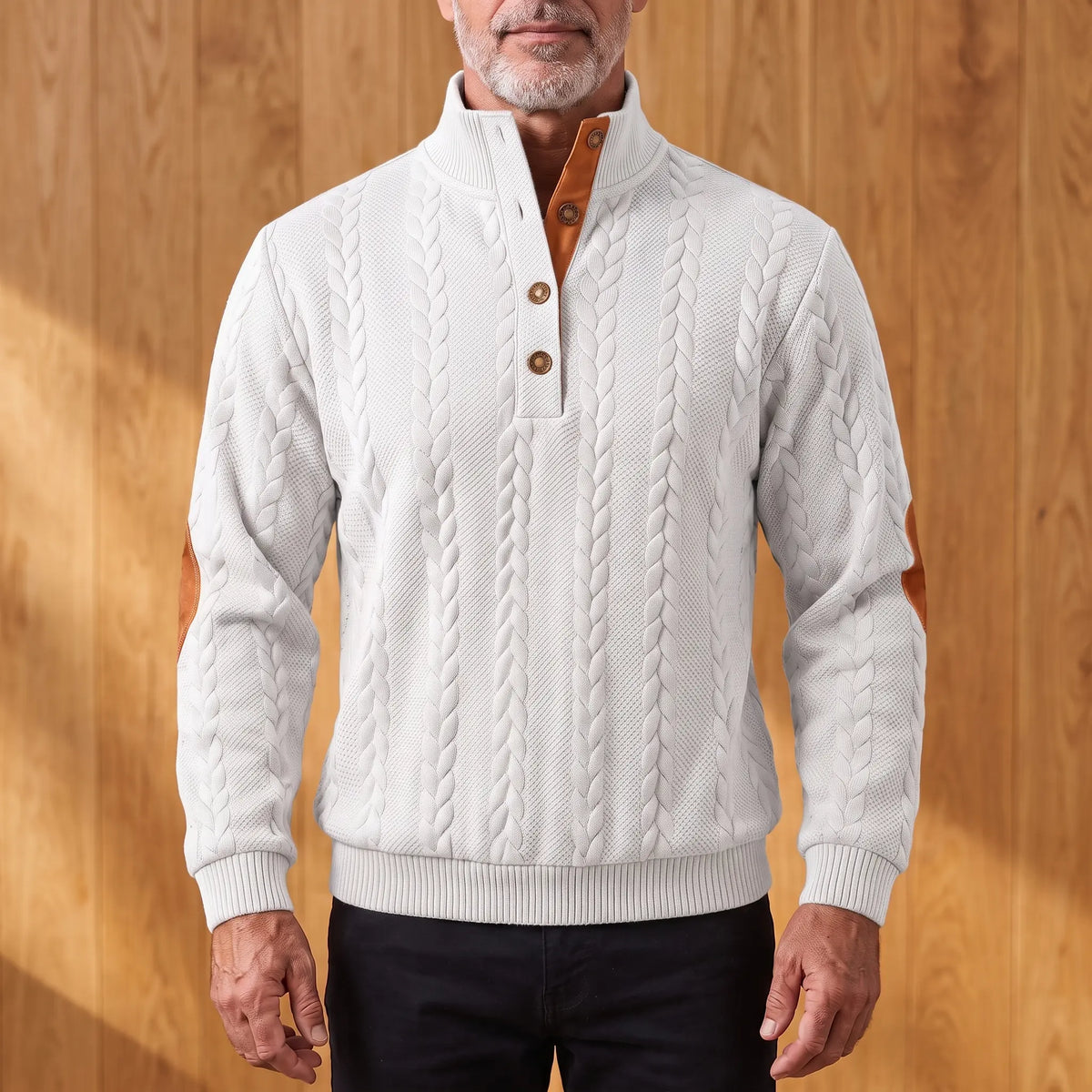 Men's off-white cable knit henley sweater with stand collar, three-button placket and tan elbow patches, worn