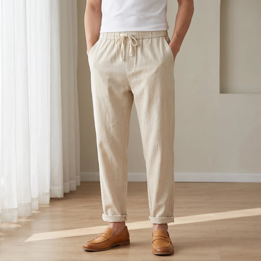 Drawstring cotton linen trousers in khaki, worn in a bright airy room