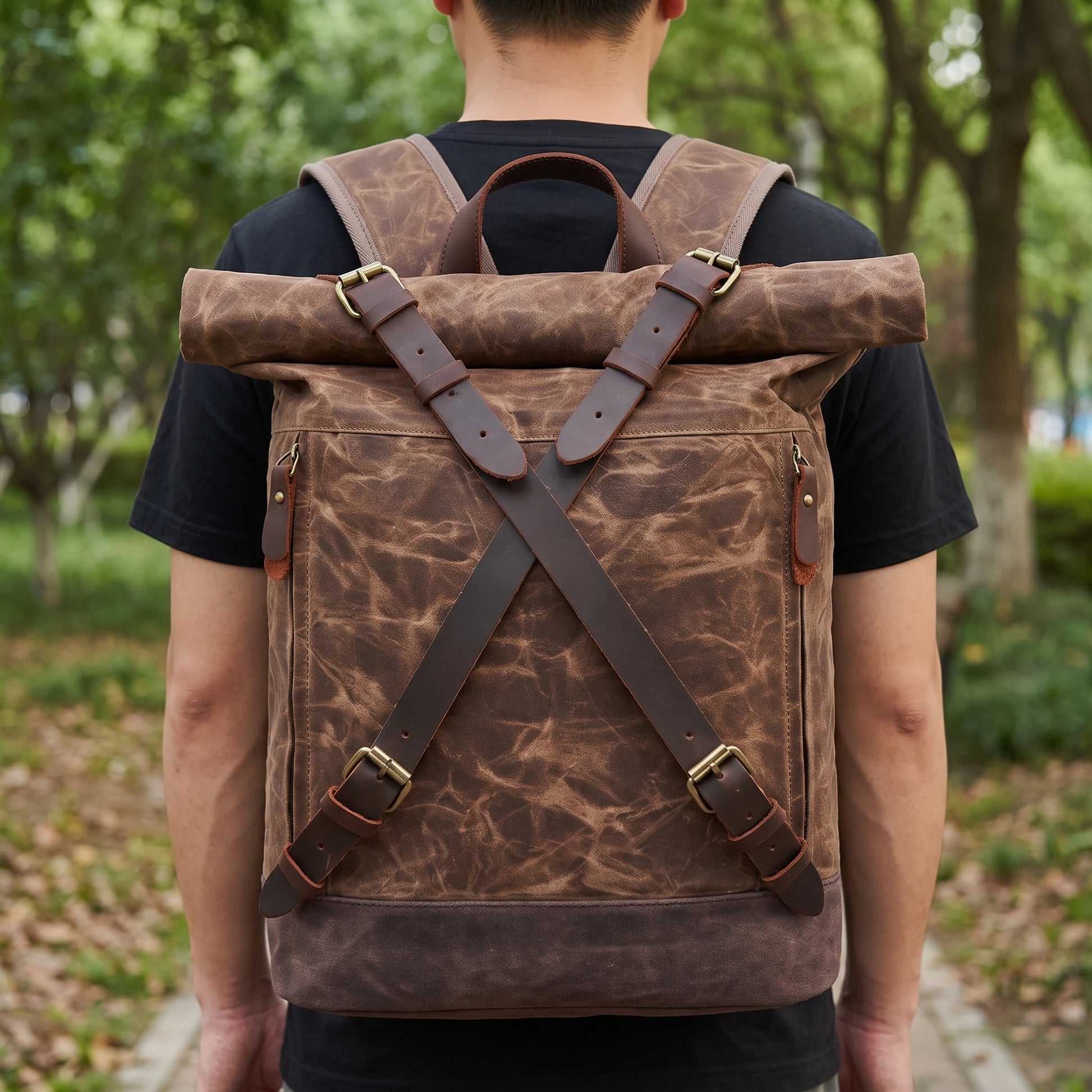 Man wearing the waxed canvas roll top backpack in a park