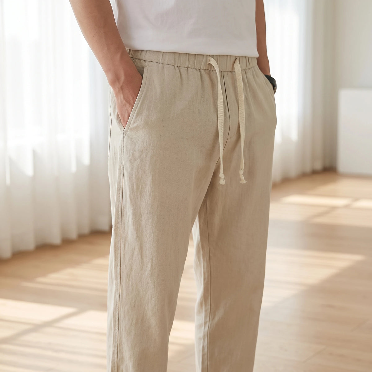 Man wearing drawstring cotton linen trousers, waist view with hand in pocket