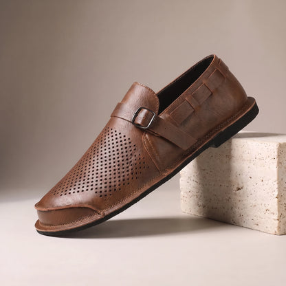 CLASSIC SLIP-ON LOAFERS brown leather slip-on loafer with woven cut-out side panel on a travertine studio block