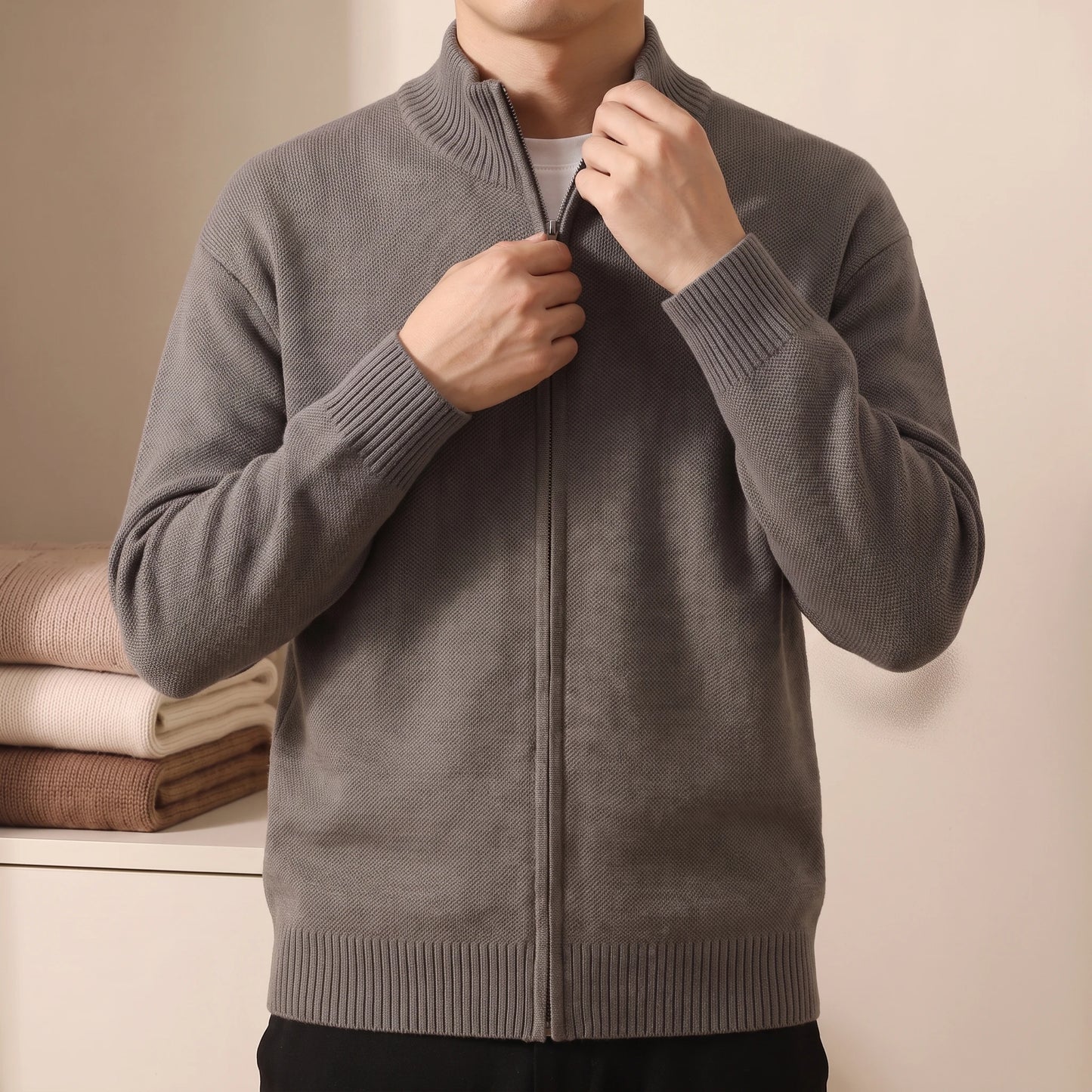 Man wearing knit zip sweater, zipping up