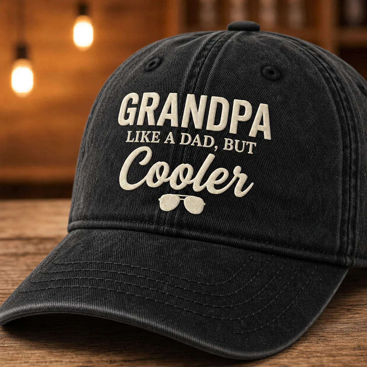 Close-up of black Grandpa Like a Dad But Cooler cap showing cream embroidery and bill stitching