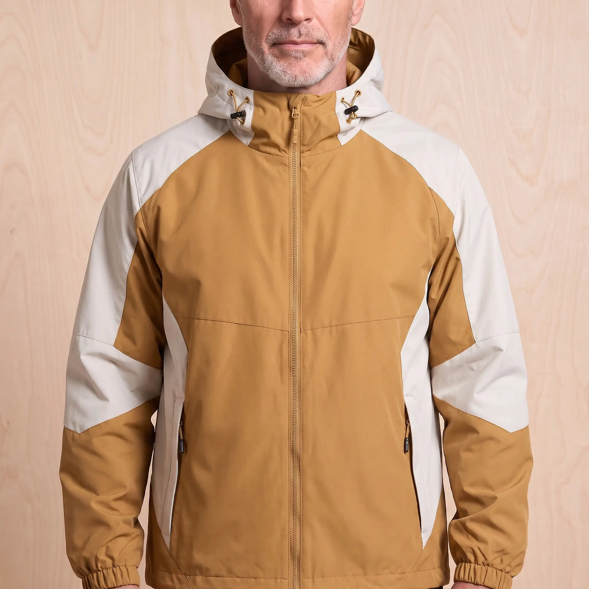 Yellow hooded panel windbreaker with cream colour block panels worn by a man, front view