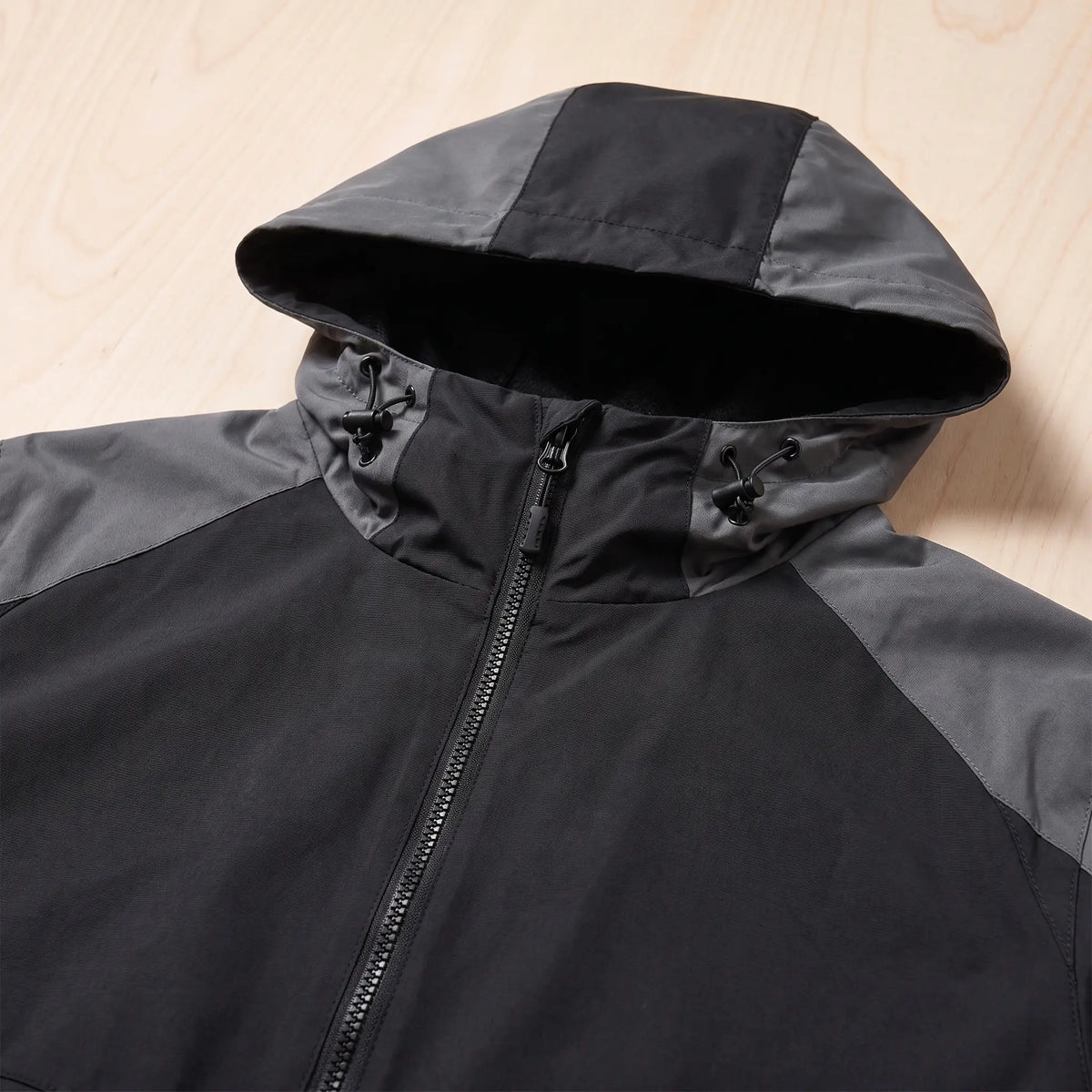 Close up of the hooded panel windbreaker hood, drawcord toggles and full length front zip