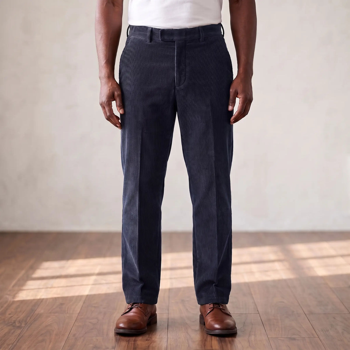 Navy blue wide wale corduroy straight leg trousers worn with a white tee and brown derby shoes