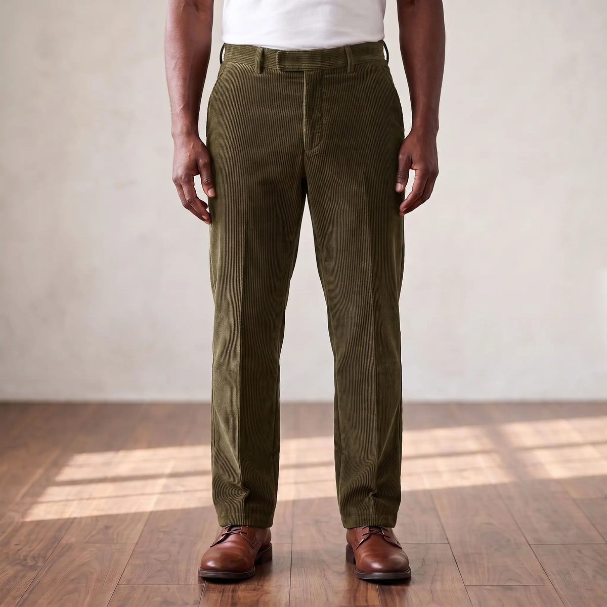 Green wide wale corduroy straight leg trousers worn with a white tee and brown derby shoes