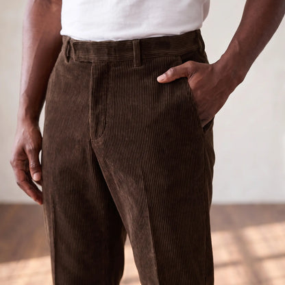 Man with his hand in the side pocket of the brown corduroy trousers, waist level view
