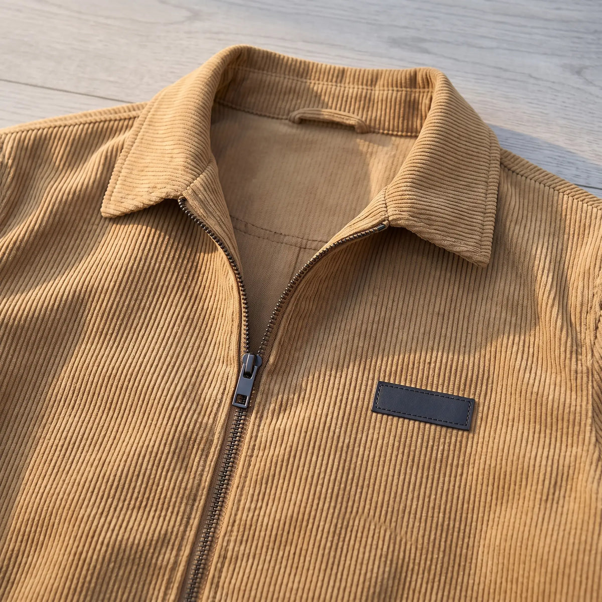 Close up of the corduroy Harrington jacket collar, front zip and chest label