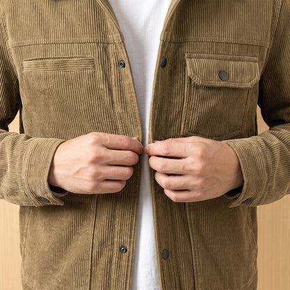 Man fastening a front button on the khaki corduroy jacket, close chest view