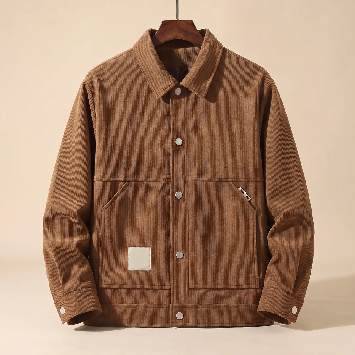 Khaki padded corduroy winter jacket with snap front on a wooden hanger, front view