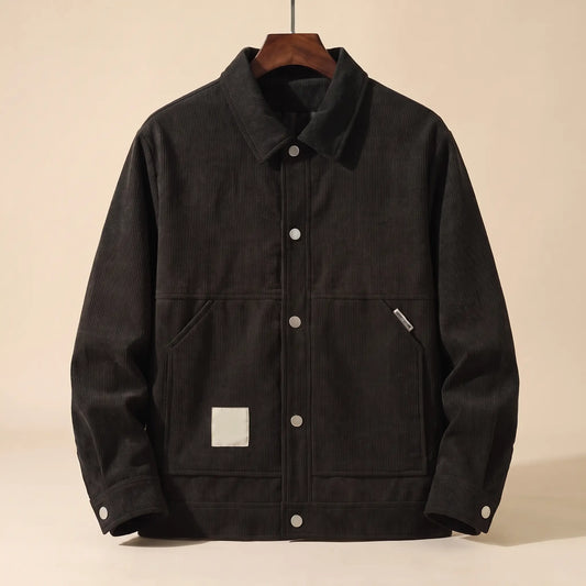Black padded corduroy winter jacket with snap front on a wooden hanger, front view