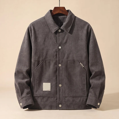 Grey padded corduroy winter jacket with snap front on a wooden hanger, front view