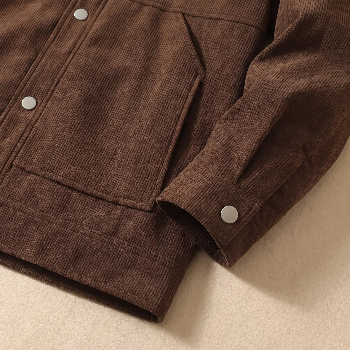 Close up of the winter corduroy jacket hem, slant pocket and snap cuff