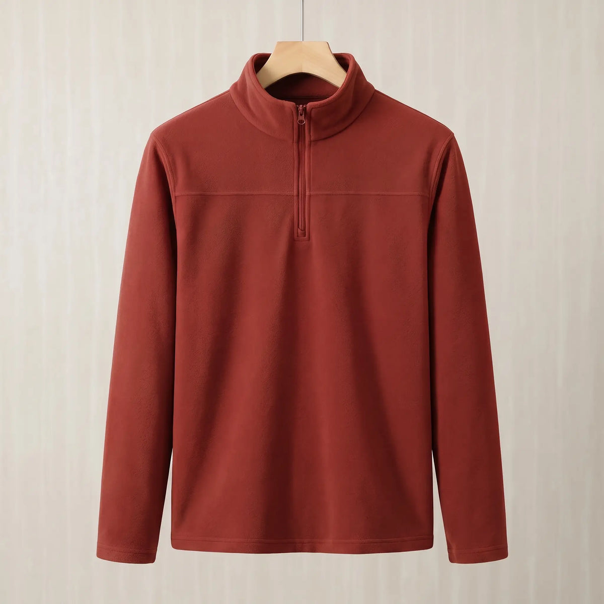 Brick red brushed fleece half zip pullover on a wooden hanger, front view