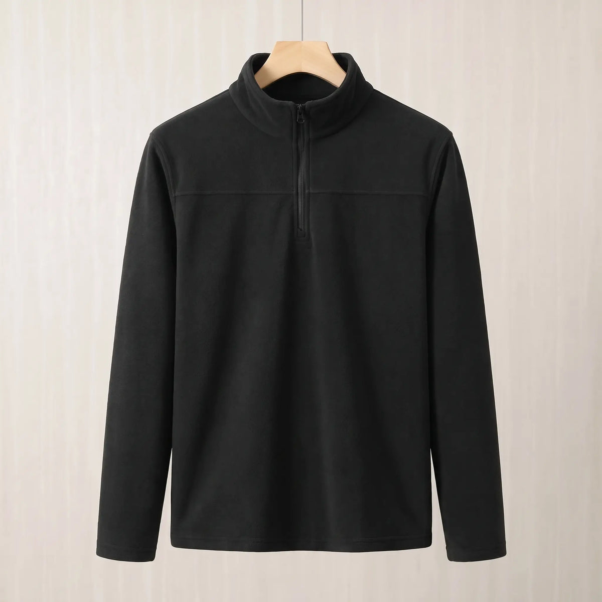 Black brushed fleece half zip pullover on a wooden hanger, front view