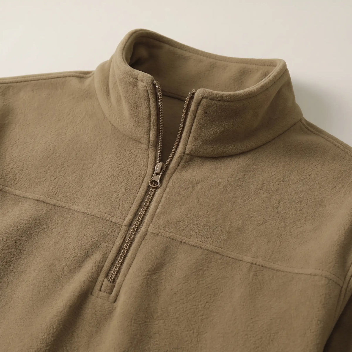 Close up of the fleece pullover stand collar, short zip and chest yoke seam