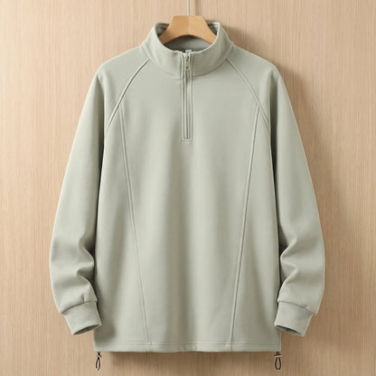 Green oversized half zip sweatshirt with tall collar on a wooden hanger, front view