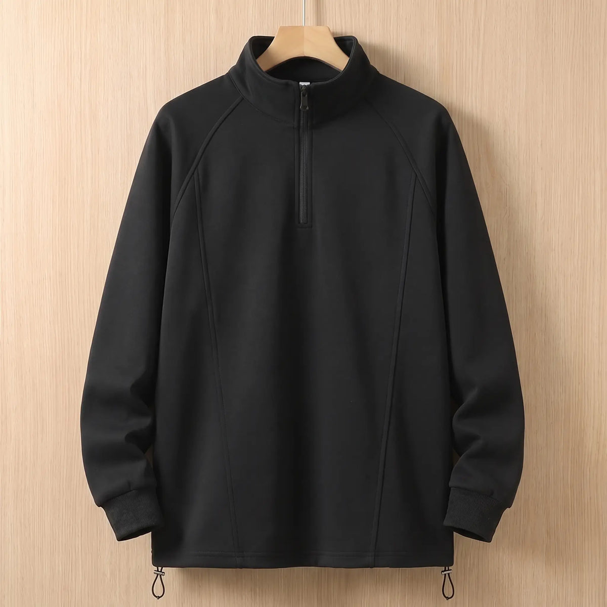 Black oversized half zip sweatshirt with tall collar on a wooden hanger, front view