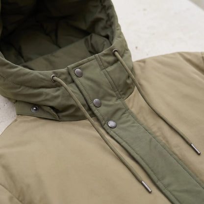 Close up of the parka hood drawcord and the metal snaps on the front panel