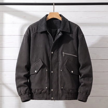Black corduroy bomber jacket with snap front placket on a wooden hanger, front view