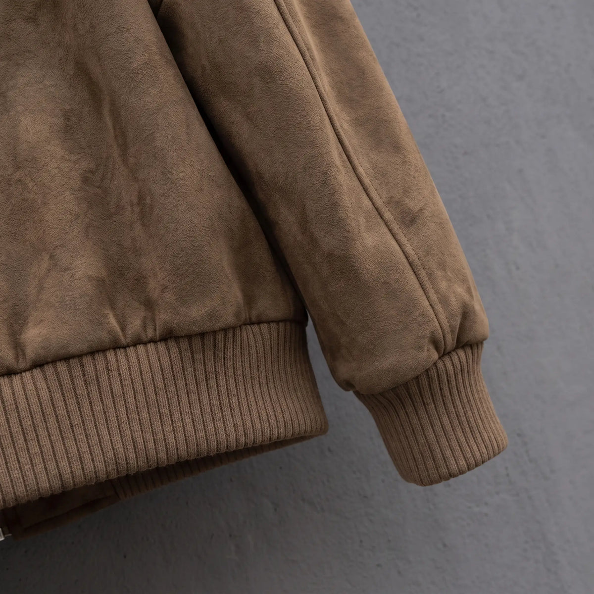 Close up of the ribbed hem band and ribbed cuff on the suede jacket