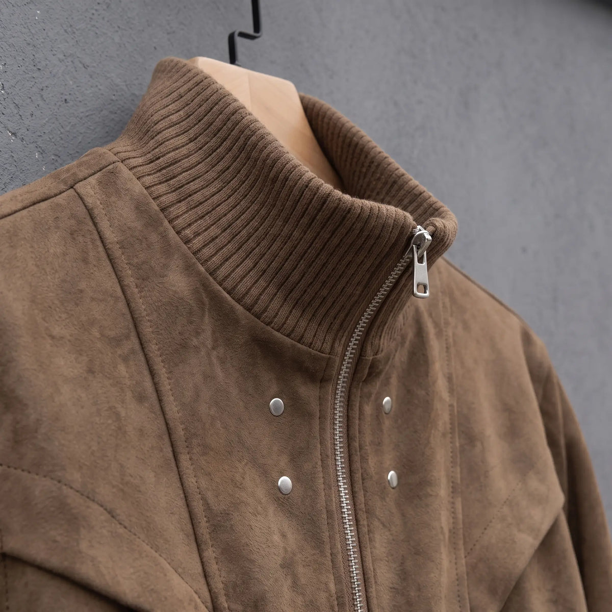 Close up of the ribbed stand collar, zip pull and chest snaps