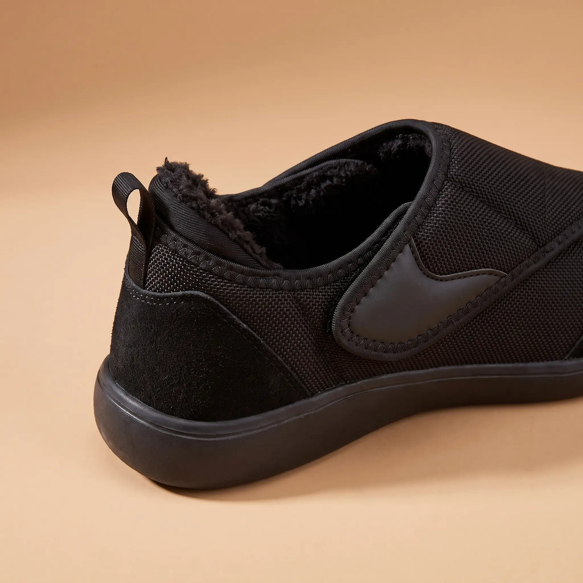 Close-up of the soft lined collar and heel loop on the black slip-on shoe