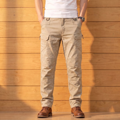 Multipocket cotton cargo pants in khaki, worn front view against a warm wood wall