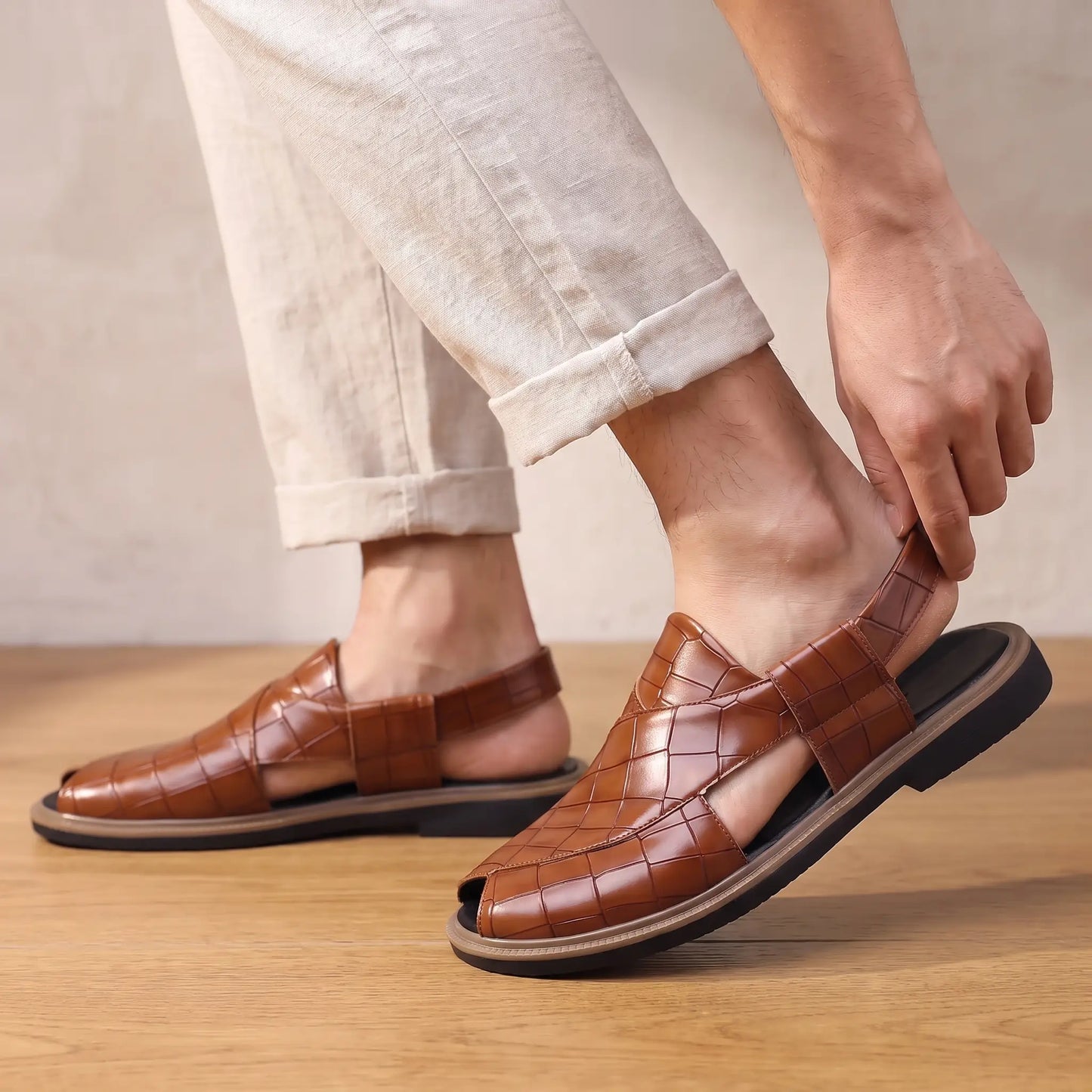 Man stepping into the brown Open Back Sandals with rolled linen trousers