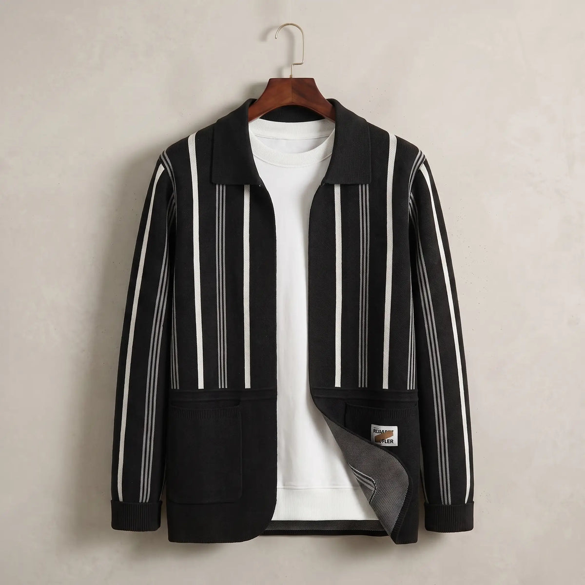 Open Front Cardigan in black with white stripes, a vertically striped knit cardigan with a turn down collar and two patch pockets on a wooden hanger