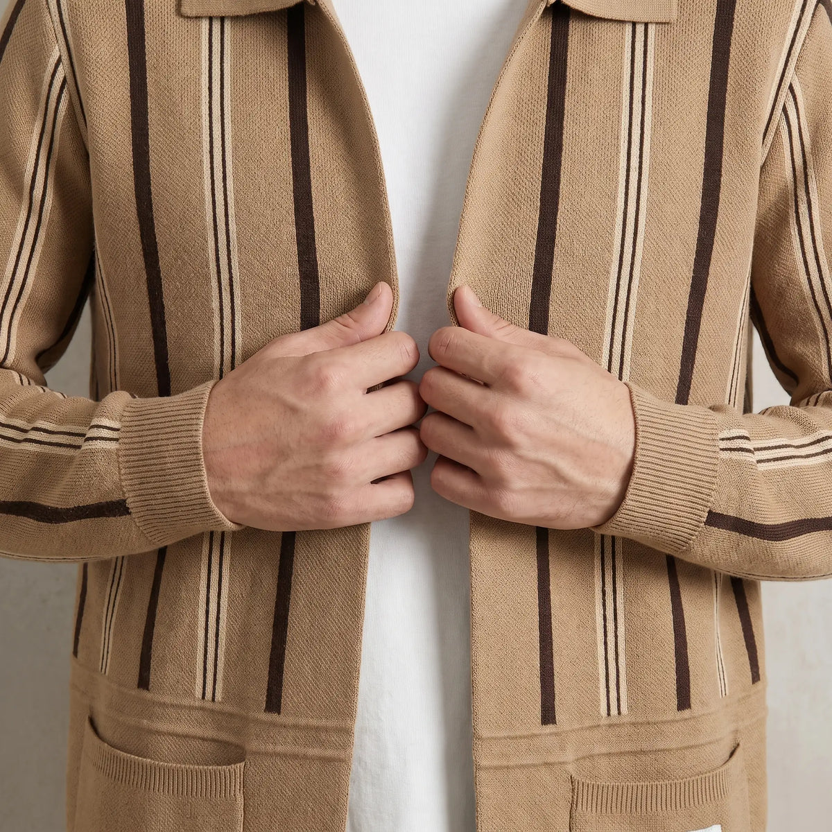 Man drawing the khaki Open Front Cardigan closed over a white tee
