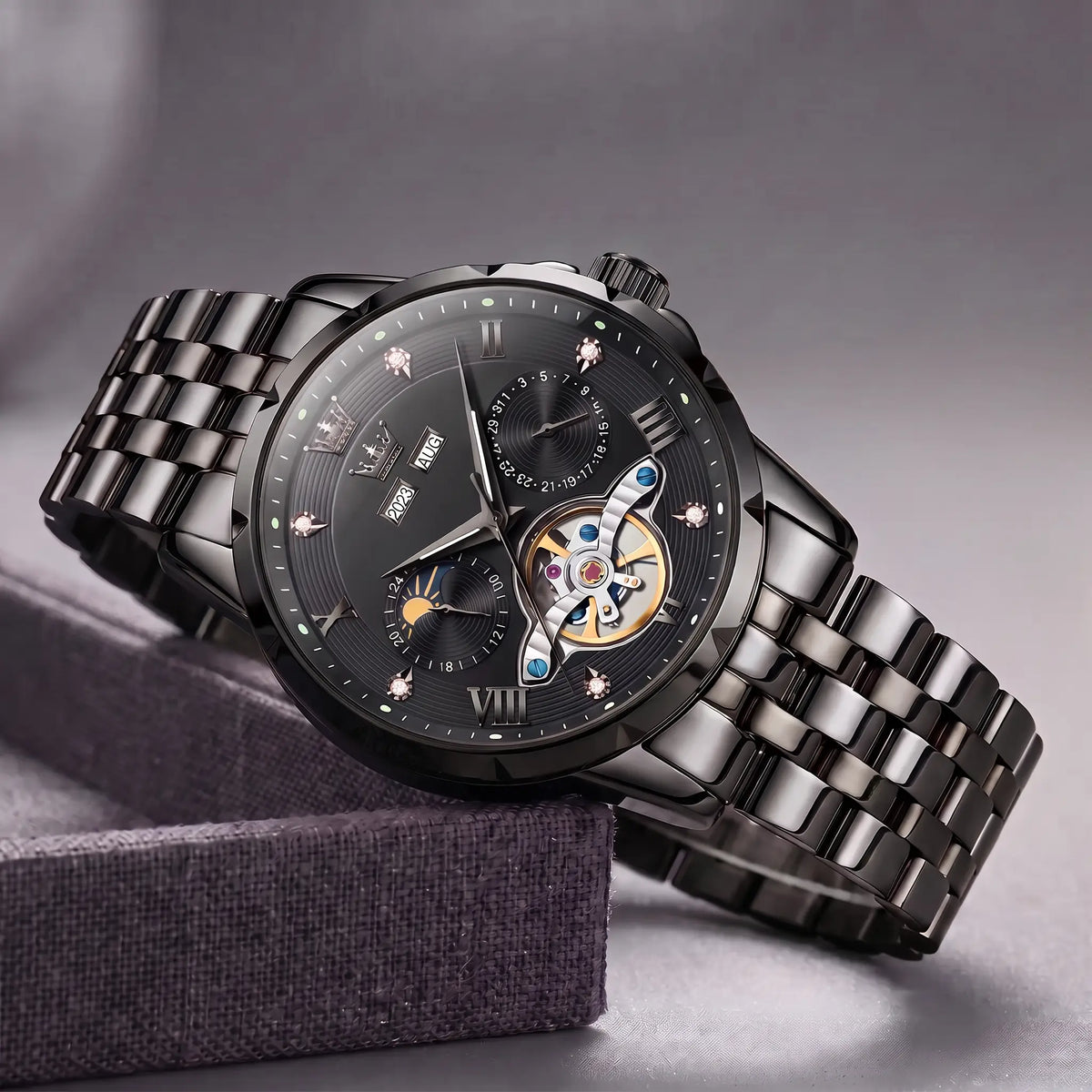 Open Heart Watch in all black with black dial, moon phase and exposed gear window, on a black steel band