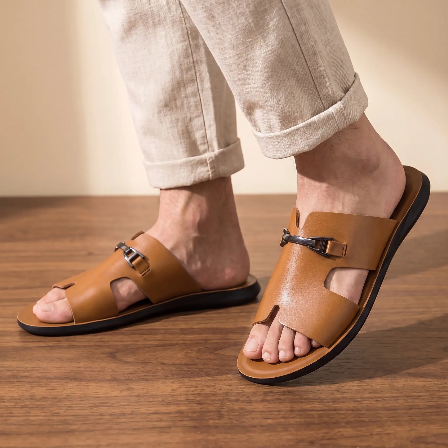 Man wearing the pair of brown buckle slides