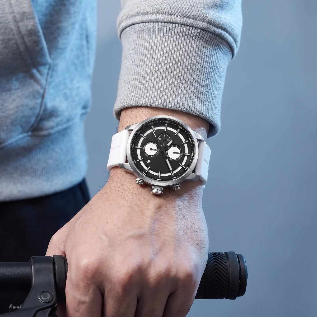 Man checking the time on the white Raised Marker Watch while holding a bicycle handlebar
