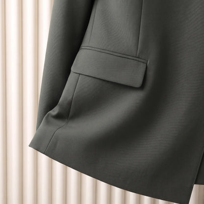 Close up of the flap hip pocket and straight hem on the green Satin Lapel Blazer
