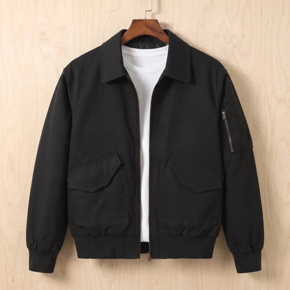 Sleeve Pocket Bomber in black, a short flight bomber jacket with a zip front, hip flap pockets and a zipped sleeve pocket on a wooden hanger