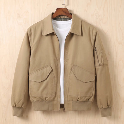 Sleeve Pocket Bomber in khaki, a short flight bomber jacket with a zip front, hip flap pockets and a zipped sleeve pocket on a wooden hanger
