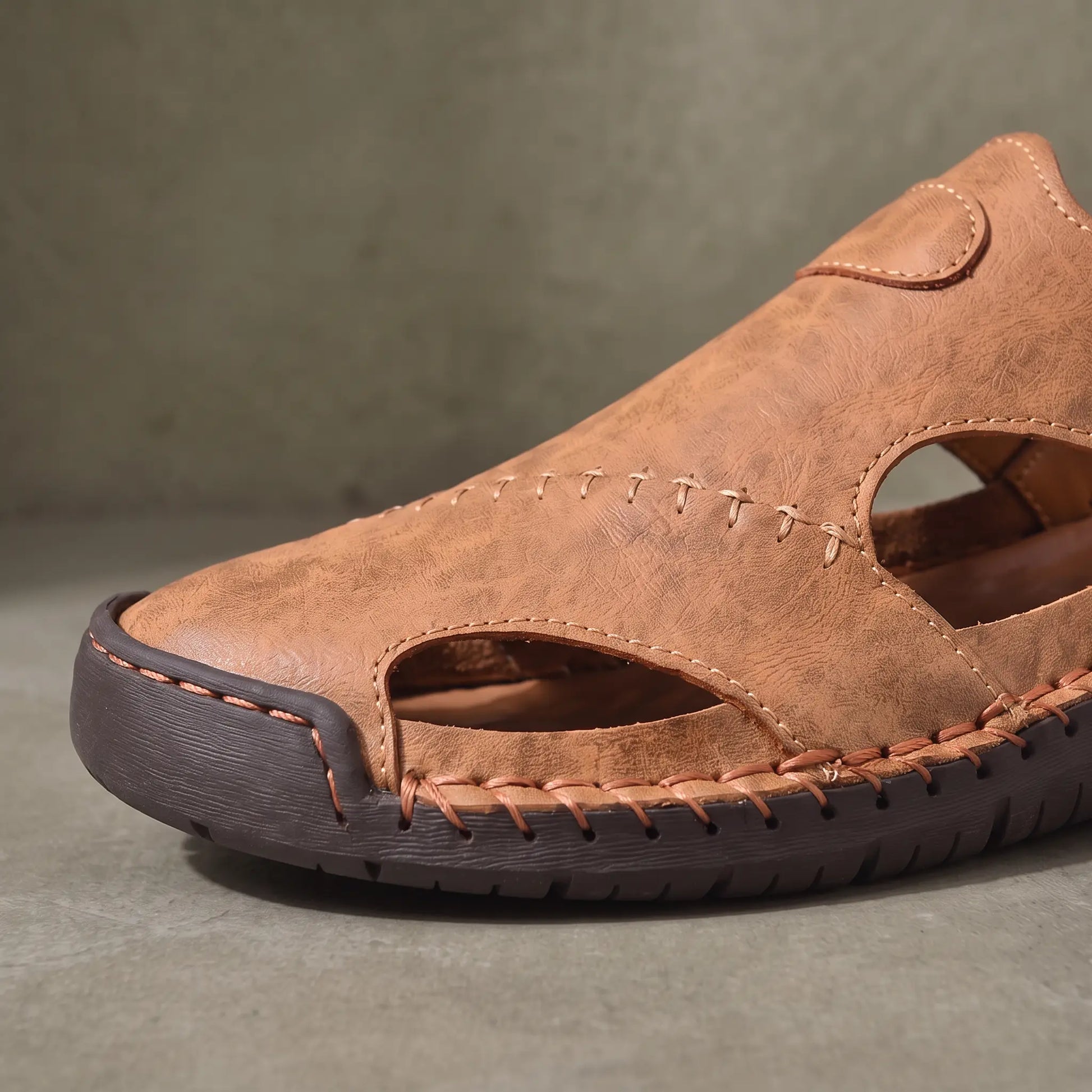 Close up of the stitched toe and cut out side panels on the light brown Snap Strap Sandals