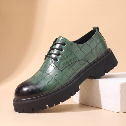 Square Scale Derby in green, a croc embossed leather derby shoe with a burnished toe cap and chunky lug sole, on a plaster block