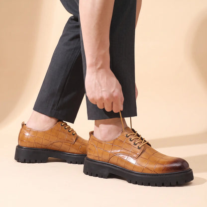 Man adjusting a lace while wearing the tan Square Scale Derby with charcoal trousers