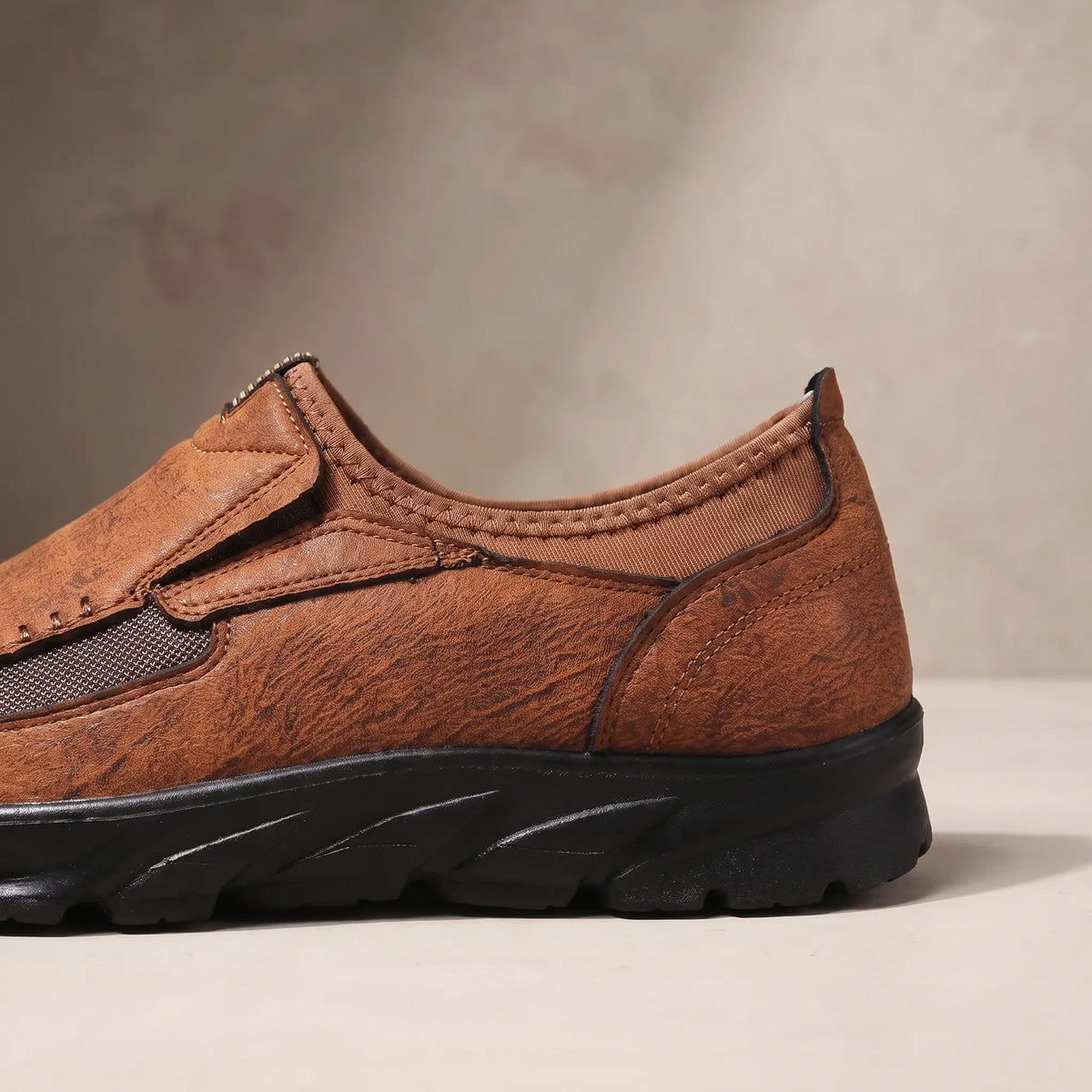 Close up of the padded collar, elastic side panel and sculpted bottom on the light brown Stitched Apron Loafers