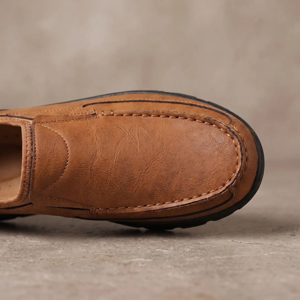 Close up of the stitched apron seam around the toe on the light brown Stitched Apron Loafers