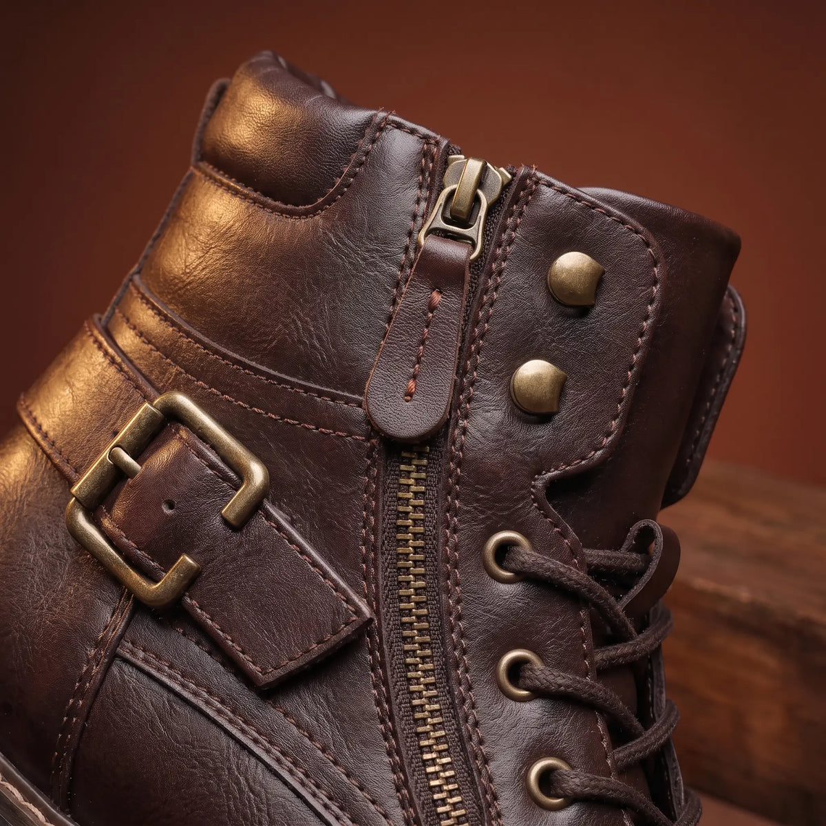 Close up of the side zip and brass ankle buckle on the Strapped Biker Boots