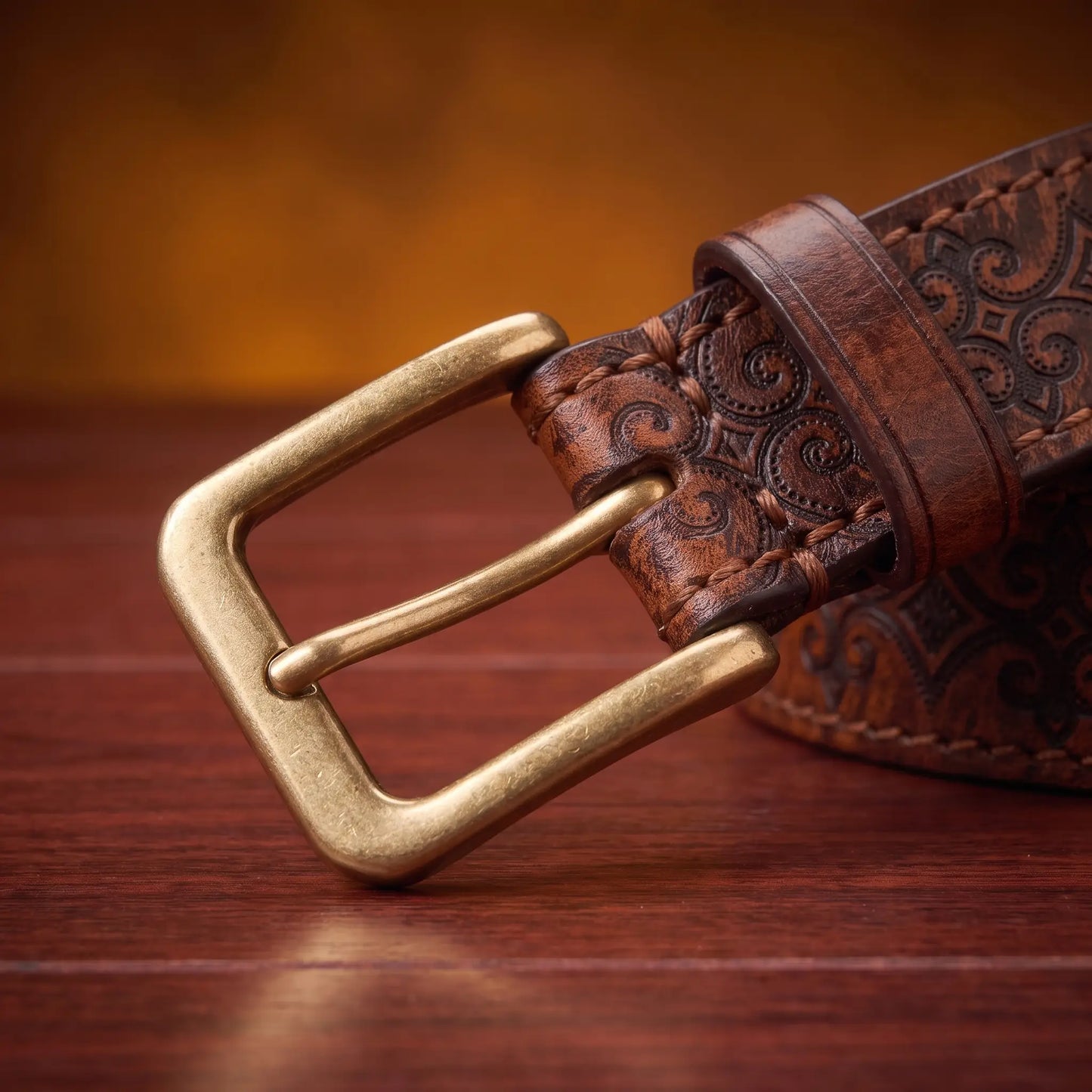 Close up of the antique brass prong buckle and leather keeper loop on the Tooled Pattern Belt